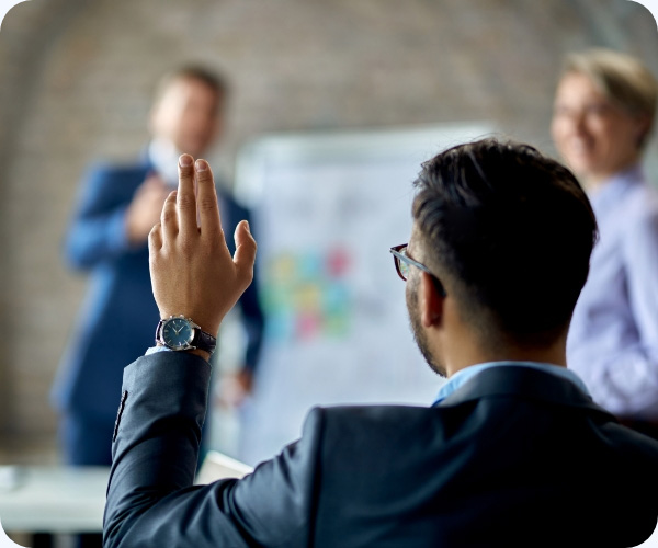 man raising hand in a meeting